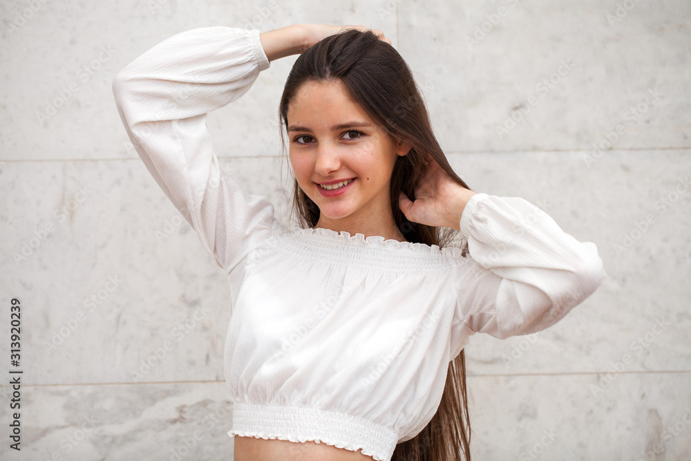 Young beautiful girl on a background of a white marble wall Young beautiful girl on a background of a white marble wall