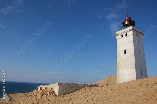 A lonely abandoned lighthouse waiting for the sea to come and for its fall in the sea. © shootingtheworld
