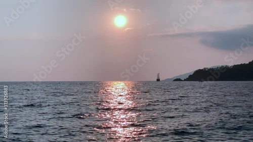 Beautiful sea sunset footage with old ship. Mountains near ocean. Summer vacation concept