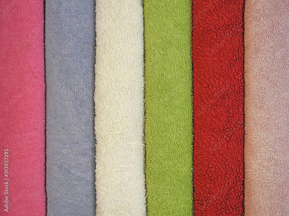 Fototapeta premium Colorful textile background of rolls of colored terry towels