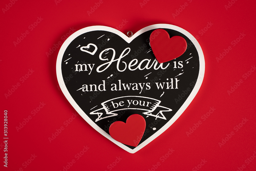 Black heart with an inscription-a Declaration of love, with red hearts, on a red background for Valentine's Day, wedding, birthday and other holidays, view from the top. Black heart with an inscription-a Declaration of love, with red hearts, on a red background for Valentine's Day, wedding, birthday and other holidays, view from the top.