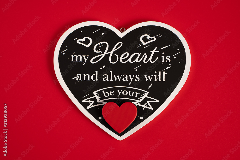 Black heart with an inscription-a Declaration of love, with red hearts, on a red background for Valentine's Day, wedding, birthday and other holidays, view from the top. Black heart with an inscription-a Declaration of love, with red hearts, on a red background for Valentine's Day, wedding, birthday and other holidays, view from the top.