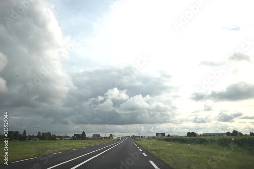 Big grey cumulus clouds above regional road N219 in the Zuidplaspolder at Zevenhuizen