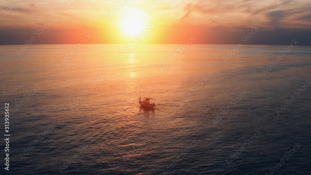 Aerial view of boat with fisherman near mediterranean coast in sea at beautiful sunset in Cyprus. Aerial view of boat with fisherman near mediterranean coast in sea at beautiful sunset in Cyprus.