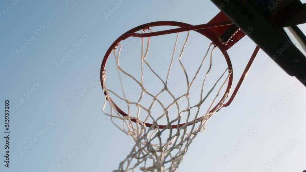 Basketball player throws ball into hoop from the top. Man scores goal