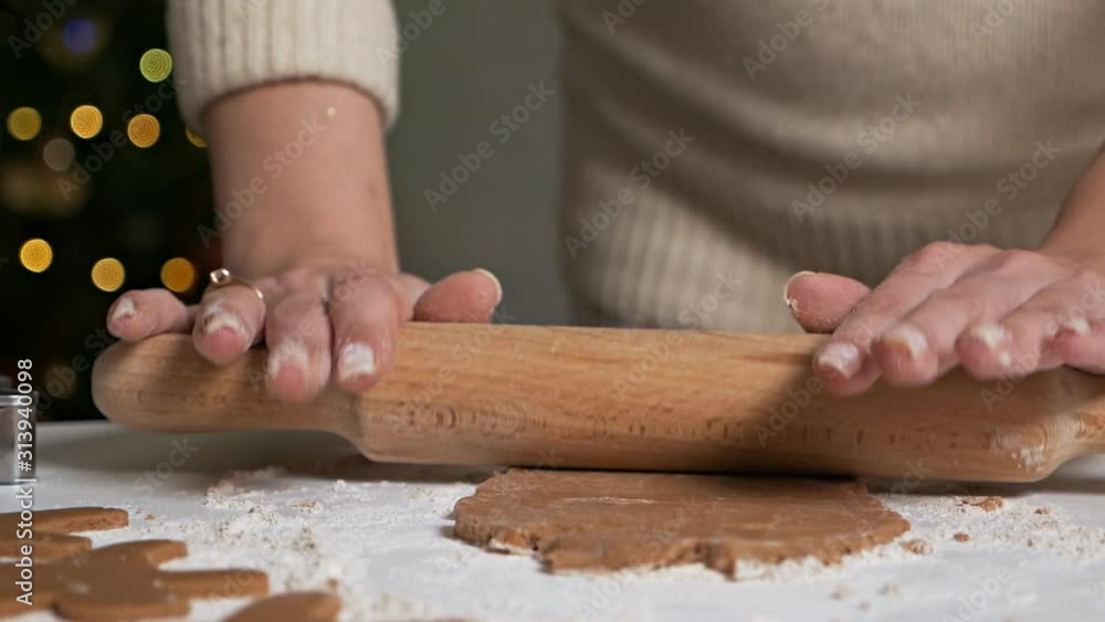 Making delicious gingerbread men.A young girl rolls dough with a rolling pin for gingerbread. Hands work with the test. Christmas sweets Making delicious gingerbread men.A young girl rolls dough with a rolling pin for gingerbread. Hands work with the test. Christmas sweets