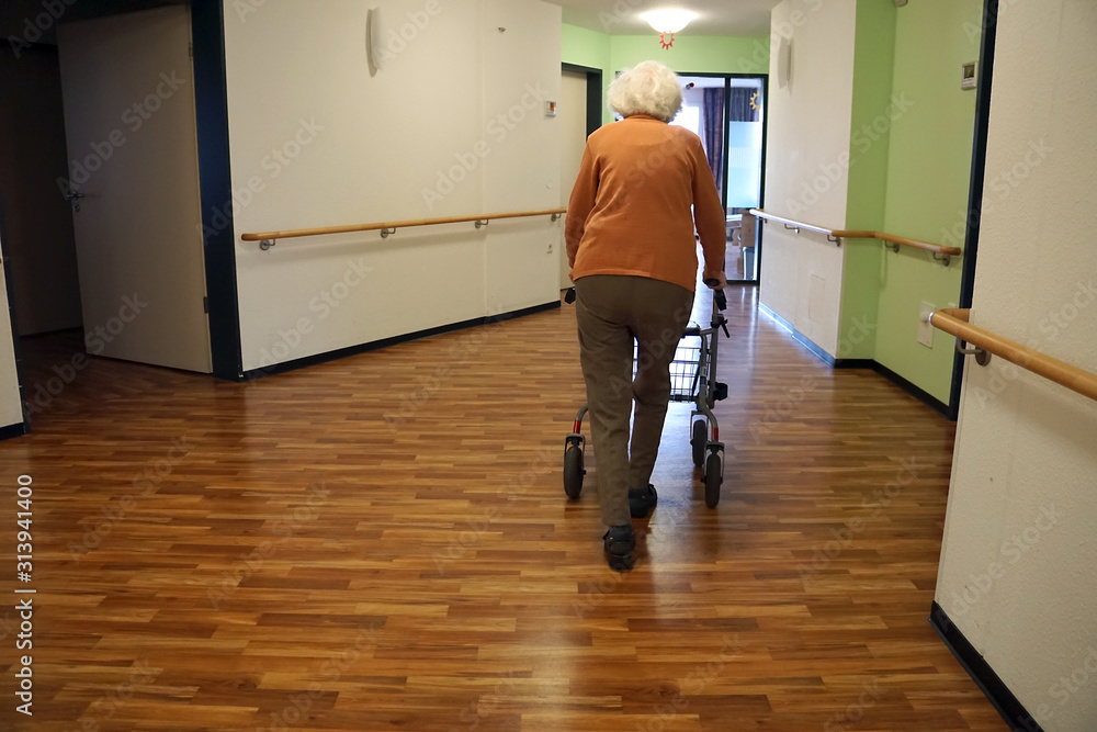 Obraz premium Frau mit Rollator läuft im Altersheim über den Flur