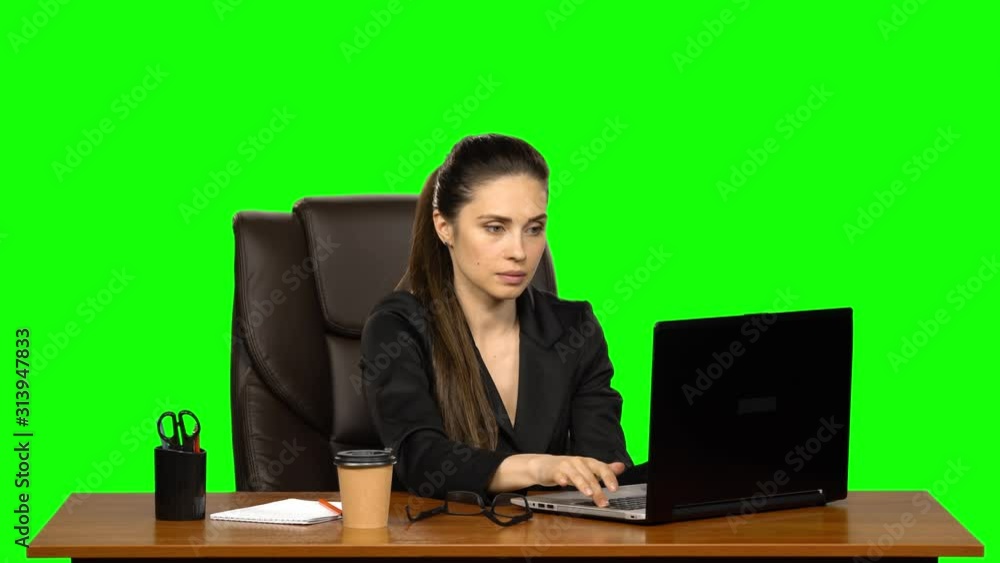 Business woman sitting at desk in leather chair and drink coffee. Green screen. Studio Business woman sitting at desk in leather chair and drink coffee. Green screen. Studio