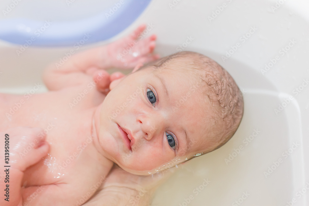 Little newborn baby having a bath. Hardening, hygiene of the newborn. Little newborn baby having a bath. Hardening, hygiene of the newborn.