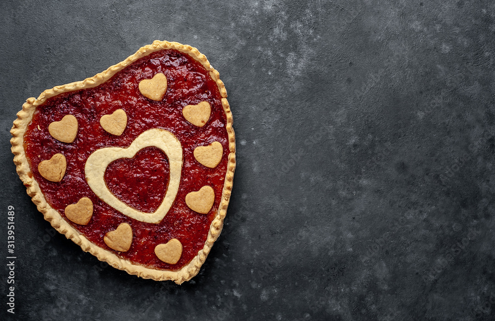 heart-shaped cake with jam on a stone background with copy space for your text. valentine's day celebration concept