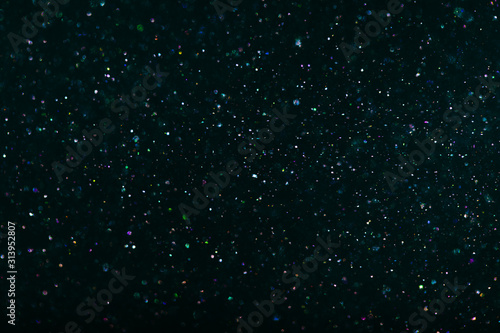 multi-colored crystalline particles, flickering magic dust on black background
