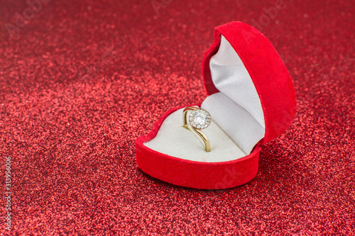 red gold ring in box on red background photo