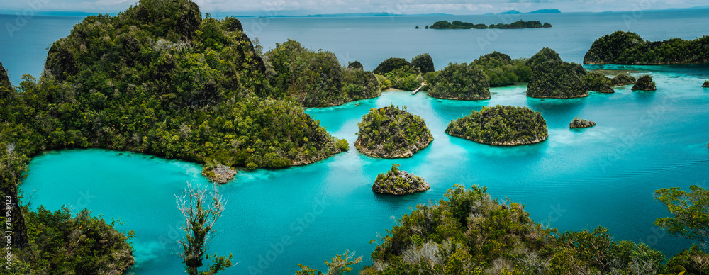 Panoramic view Pianemo Islands, Blue Lagoon with Green lush karst lime stone Rockes, Raja Ampat, West Papua. Indonesia