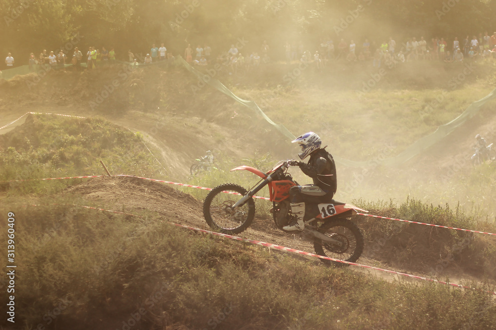 Fototapeta premium Motorcyclist in a motocross competition climbing up a dusty summer road