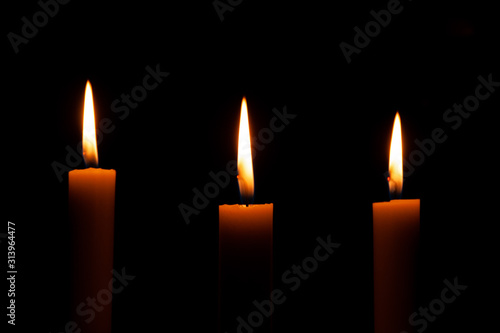 three candles on a black background mourning for the victims