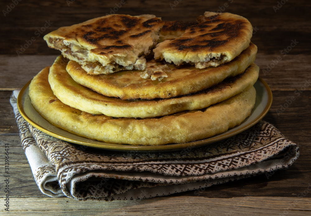 Rustic, homemade tortillas with meat on a kitchen napkin, on a wooden table. Rustic, homemade tortillas with meat on a kitchen napkin, on a wooden table.