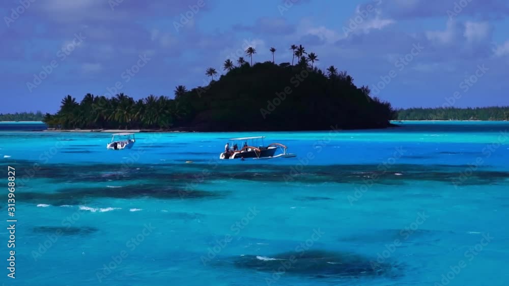 Low angle drone glide shot. Tourist boats in turquoise lagoon with coral reef. Bora Bora, Tahiti French Polynesia. Luxury honeymoon vacation, tropical romantic getaway, exotic resort destination. Low angle drone glide shot. Tourist boats in turquoise lagoon with coral reef. Bora Bora, Tahiti French Polynesia. Luxury honeymoon vacation, tropical romantic getaway, exotic resort destination.