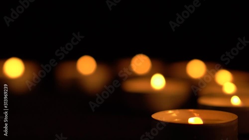 Slow motion white candles light up flames fire on isolated black background. Use in romantic dinner, warm and relax peace maditaion, use for spiritual religion church decotion and Halloween graveyard