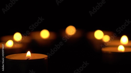 Slow motion white candles light up flames fire on isolated black background. Use in romantic dinner, warm and relax peace maditaion, use for spiritual religion church decotion and Halloween graveyard