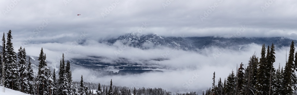 Whistler, British Columbia, Canada. Beautiful Panoramic View of the Canadian Snow Covered Mountain Landscape during a cloudy and foggy winter day.