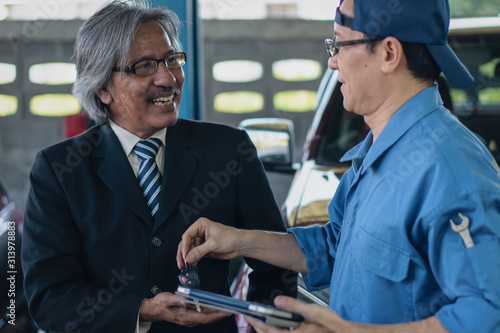 Foto elder customer show happy face in satisfy of mechanic's service at garage and ca