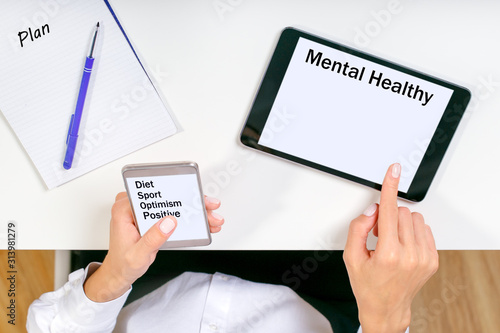 Concept with mobile phone and business woman, text Mental Healthy. Woman plans her mental healthy.
