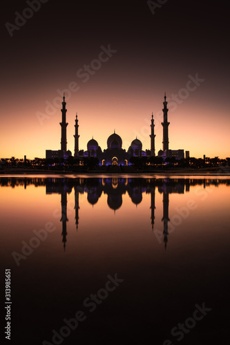 Sheikh Zayed Grand Mosque with its reflection shortly after sunset. Abu Dhabi, United Arab Emirates.