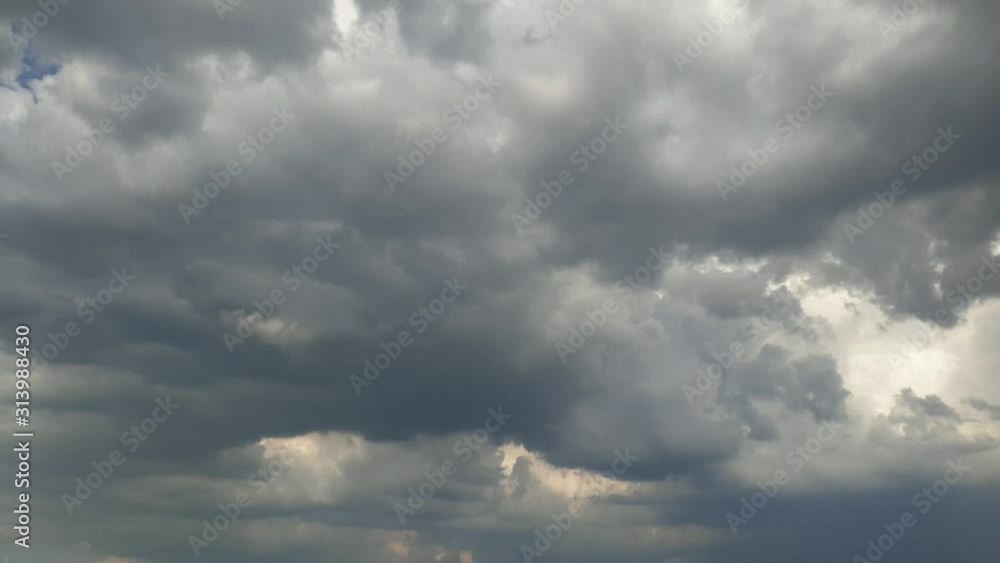 Scary dark hail storm clouds in sky with dense thick rain clouds moving across the heavens. Fast cloud formation and movement creating a surreal time lapse. Scary dark hail storm clouds in sky with dense thick rain clouds moving across the heavens. Fast cloud formation and movement creating a surreal time lapse.