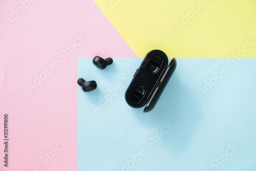 Vászonkép Black true wireless earbuds headphones with power bank case over colorful pastel color