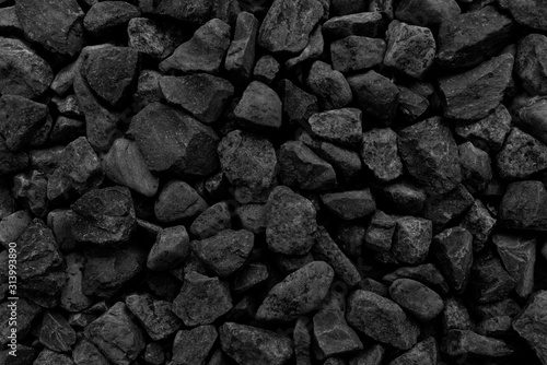  Natural fire ashes with dark grey black coals texture. It is a flammable black hard rock. Space for text.