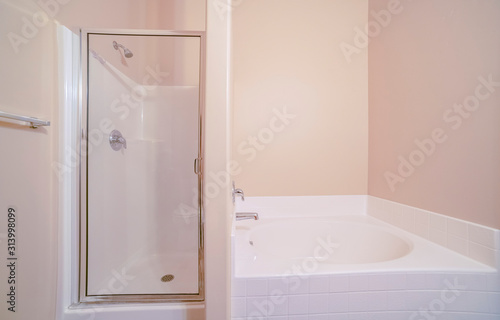 Shower cabin and bathtub in bathroom in home