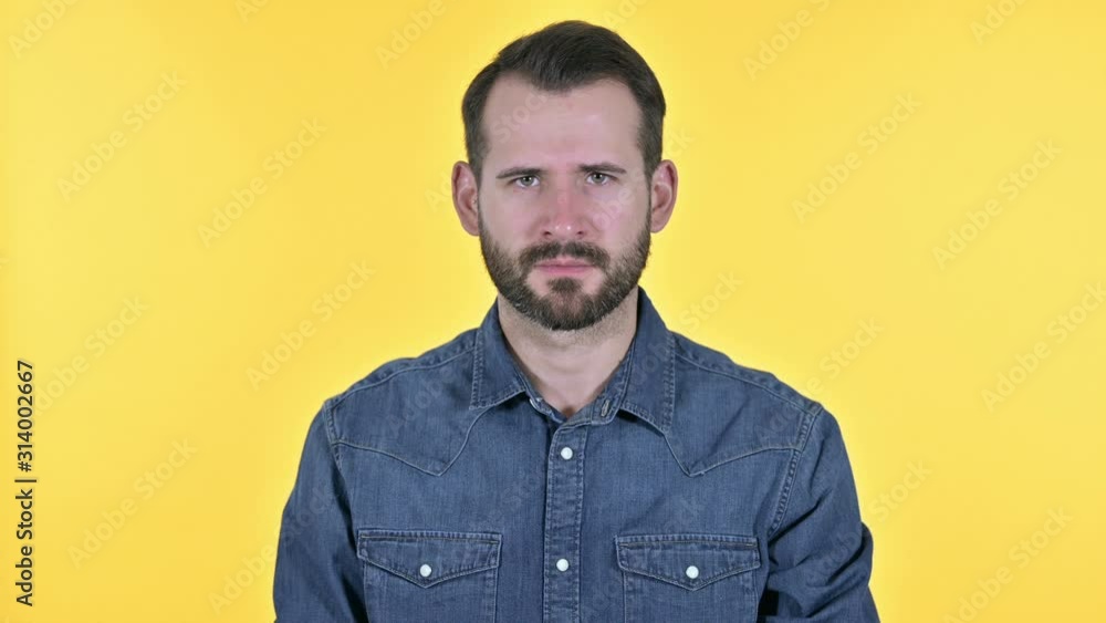 Angry Beard Young Man Showing Middle Finger, Yellow Background Angry Beard Young Man Showing Middle Finger, Yellow Background