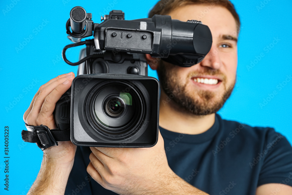 Operator with professional video camera on blue background Operator with professional video camera on blue background