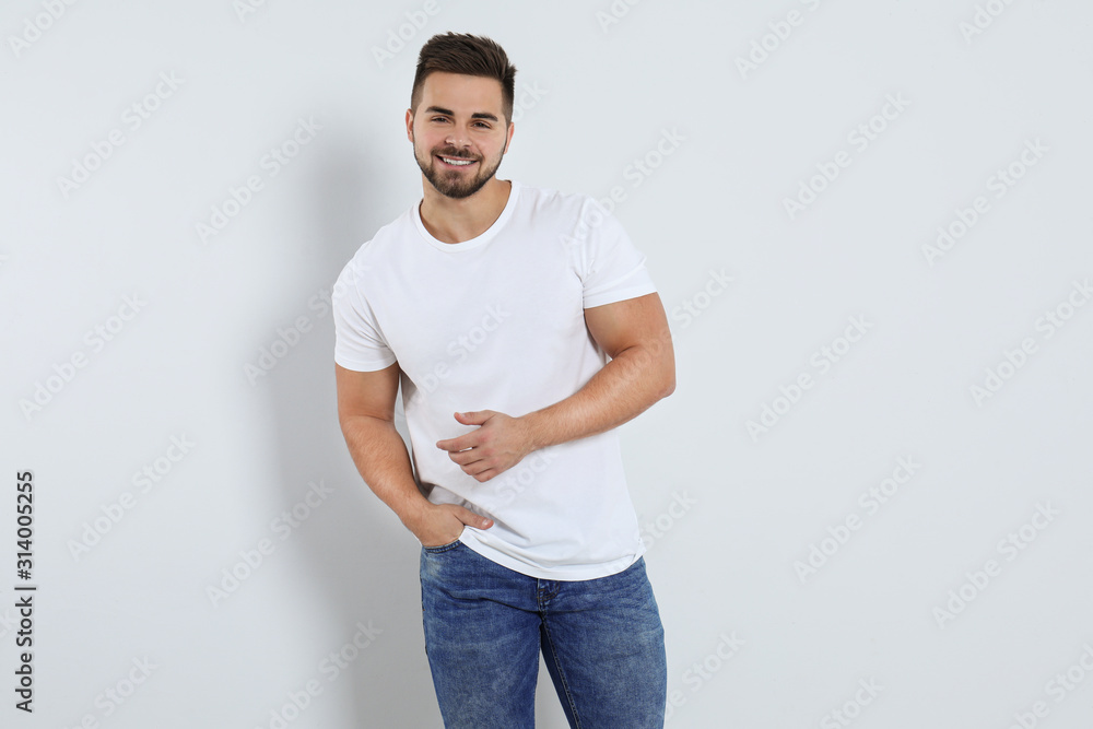 Fototapeta premium Young man in stylish jeans on light background
