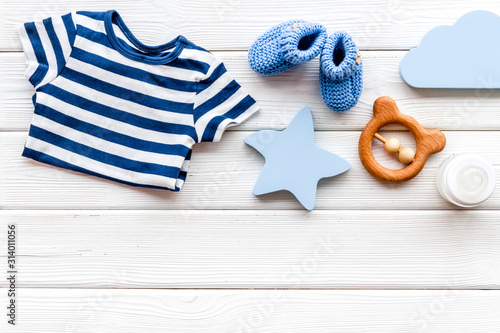 Baby background - blue color. Clothes and accessories for newborn boy on white wooden table top-down frame copy space