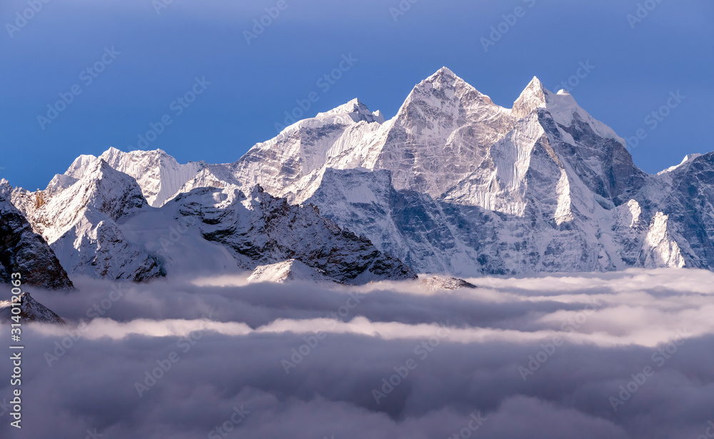 Majestic Himalayan peaks towering above the clouds at sunrise in Nepal, Himalayas mountains. Kangtega peak (6782 m) on the right side of the frame