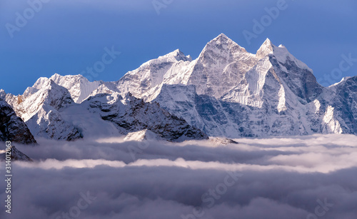 Majestic Himalayan peaks towering above the clouds at sunrise in Nepal, Himalayas mountains. Kangtega peak (6782 m) on the right side of the frame