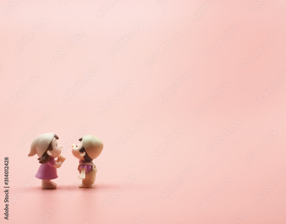 The pink background wallpaper copy space has two red heart. Left image girl  and boy doll