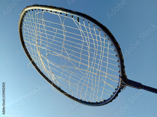 a broken wire racket whit light blue background