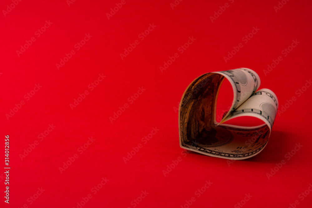 Heart made of dollar bill on a red background Stock Photo | Adobe Stock