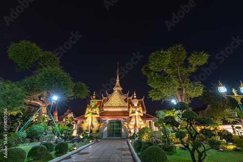 Large illuminated temple Wat Arun after sunset seen accross river Chao Phraya Bangkok, Thailand.golden Buddha in side temple Wat Arun the biggest and tallest pagoda in the world