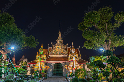 Wallpaper Mural Large illuminated temple Wat Arun after sunset seen accross river Chao Phraya Bangkok, Thailand.golden Buddha in side temple Wat Arun the biggest and tallest pagoda in the world Torontodigital.ca