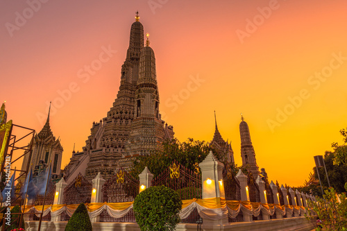 Large illuminated temple Wat Arun after sunset seen accross river Chao Phraya Bangkok, Thailand.golden Buddha in side temple Wat Arun the biggest and tallest pagoda in the world © Narong Niemhom