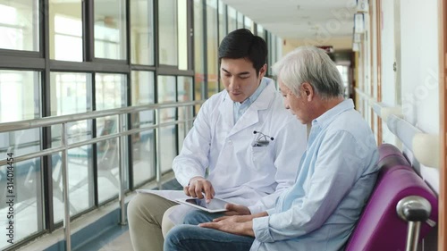 young asian doctor explaining test result and medical condition elderly male patient