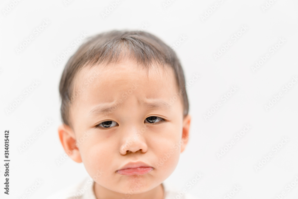 Sick little asian toddler boy make unhappy face and serious face.He is very dehydrated, dry lips and canker sore.White background. Sick little asian toddler boy make unhappy face and serious face.He is very dehydrated, dry lips and canker sore.White background.