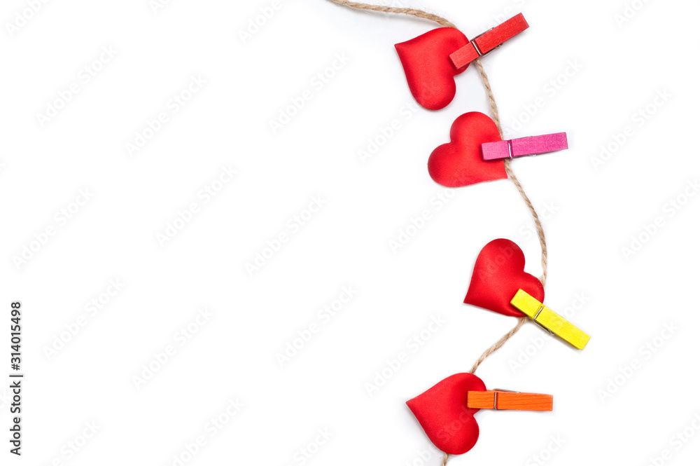 Naklejka premium Valentine's Day on February 14th. Lot of red hearts on a clothespin on a rope. White background. Valentine concept. Isolated. Wallpaper, flyers, invitations, posters, brochures, banners.