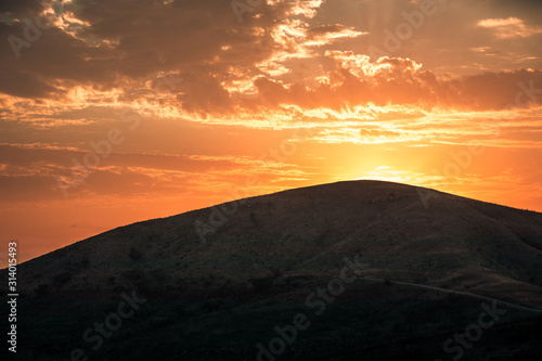 The sun rising at dawn over the hills of the Hluhluwe - imfolozi National Park in South Africa © Giulio