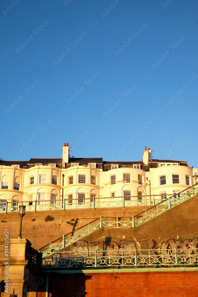 A Typical Brighton Georgian houses on the seafront a staircase in a big brick wall leading to the beach, Brighton, Sussex, UK. a big blue sky, ideal copy space
