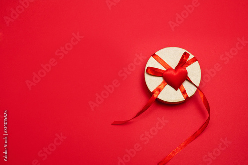 Valentine's day. Craft box with red ribbon on a red background. Isolate. Wallpaper, flyers, invitations, posters, brochures, banners. photo