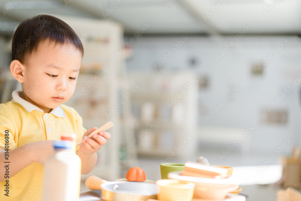 2.9 years old boy.Little child boy playing with lots of wooden toys kitchen ware like a chef.Kid play with montessori toys for imagine color.Day care and Kindergarten school.child development concept.